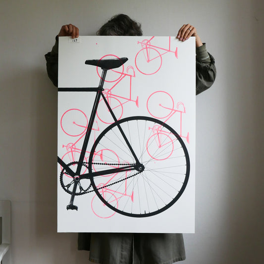 Person holding a large poster of a black bicycle with red outlines against a white background.