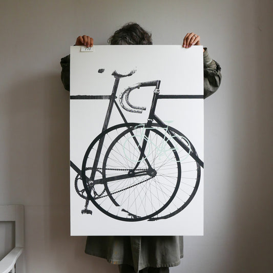 Person holding a large black and white bicycle illustration on a white background